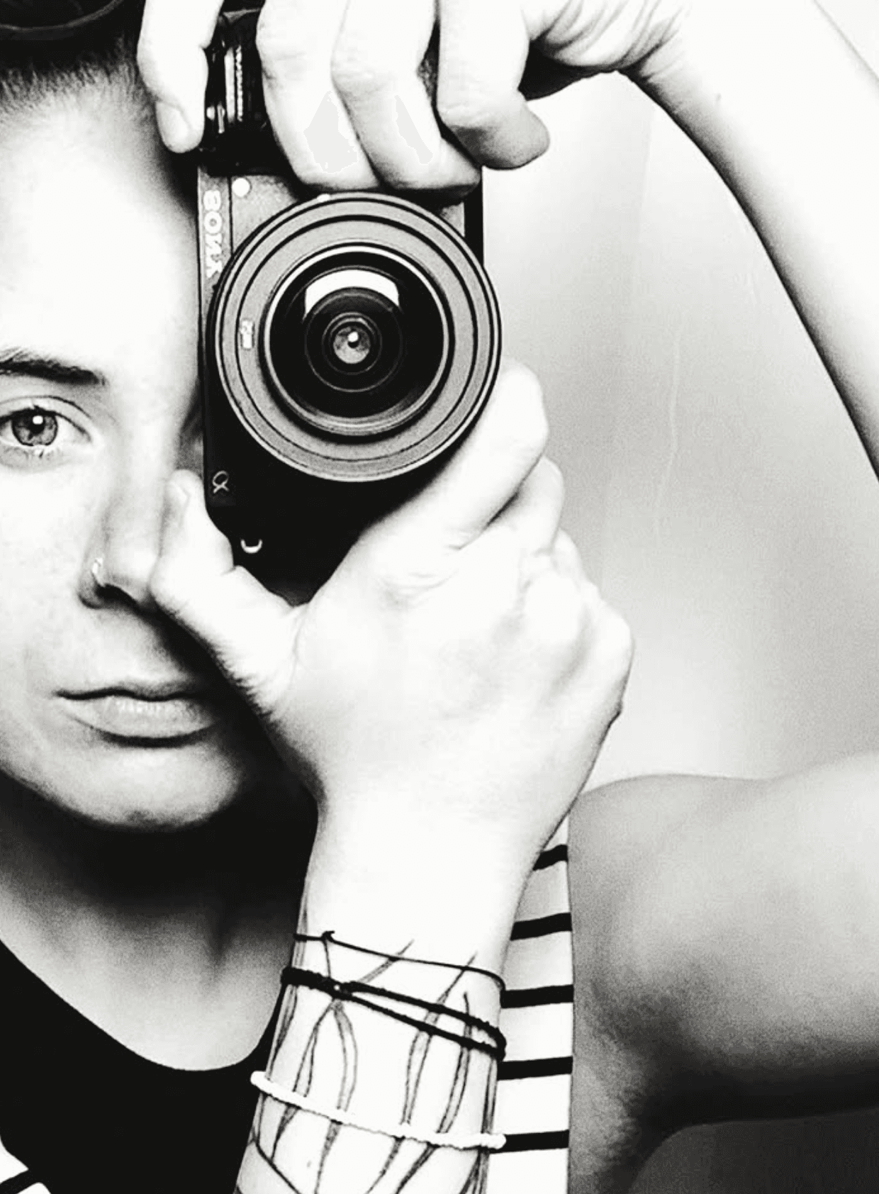 Black and white self-portrait of photographer Nagy Niki, camera raised to one eye